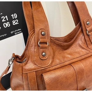 Close-up of vintage brown pebble leather texture, metal rivets and zipper detail
