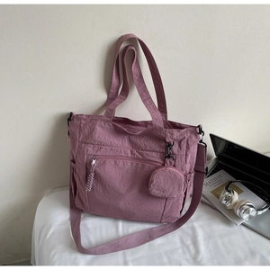Detailed view of pink nylon tote bag with functional zippers and detachable coin purse