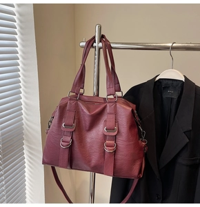Close-up of burgundy PU leather tote bag with silver D-ring detail and vertical straps