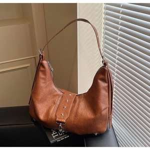 Detail of vintage brown leather tote bag featuring metal star accents and texture