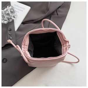Detailed macro view of pink shell crossbody bag with lychee grain texture and inner pocket