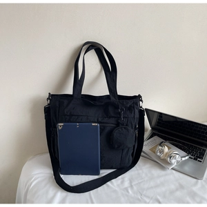 Close-up of large nylon tote bag showing space for a tablet and detachable pouch