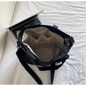 Internal view of large nylon tote bag showing dual open pockets and golden satin lining