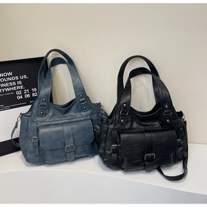 Detail of vintage soft PU leather tote bags in dark blue and black with front buckle pockets