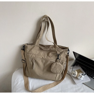 Close-up of khaki nylon tote bag with texture, laptop and headphones for commute