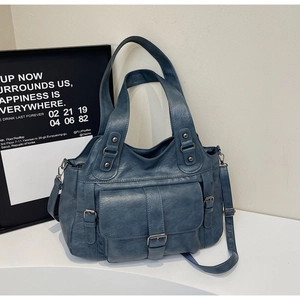 Detail view of retro navy blue tote bag with metal buckles, rivets and adjustable strap