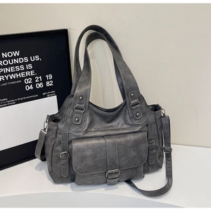Close-up of vintage grey faux leather handbag with silver studs and buckle pocket