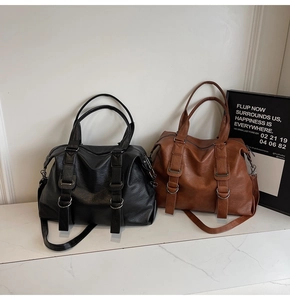 Close-up of black and brown large tote bags featuring textured faux leather and metal buckles