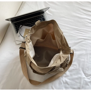 Top view of khaki nylon tote bag interior with multiple compartments and a laptop