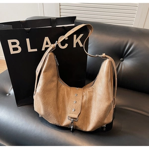 Detailed close-up of brown distressed leather hobo bag with silver star rivet accents