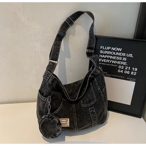 Detail of black washed denim crossbody bag featuring a round coin purse and cargo pocket