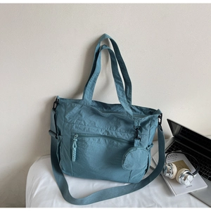 Detail of grey-blue nylon tote bag with adjustable strap and small round coin purse pouch