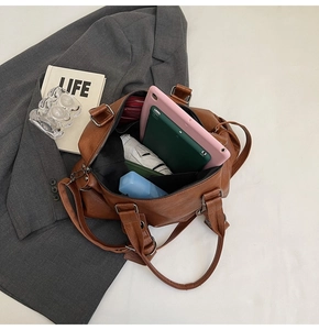 Spacious retro brown PU tote bag interior filled with tablet, umbrella and makeup