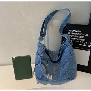 Detail of blue denim hobo bag featuring external pockets and a round matching coin purse