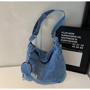 Detail of vintage washed denim crossbody bag with adjustable strap and small coin purse