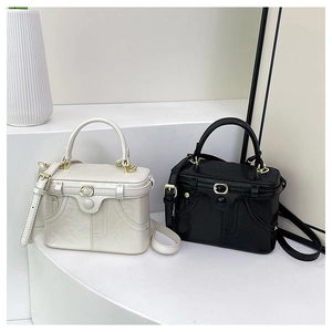 Dual view of black and white vintage box bags with gold hardware on minimalist stairs