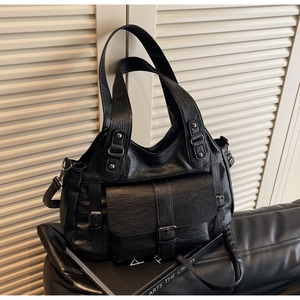 Detail of black vintage PU leather tote showing natural crack texture and belt buckle