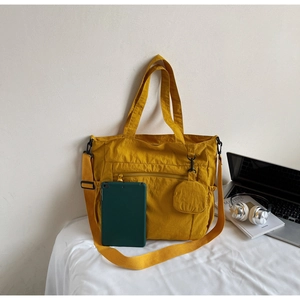 Detailed view of yellow nylon tote bag with detachable strap and round coin purse pouch