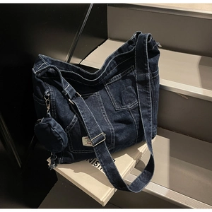 Detail of dark blue denim tote bag with white contrast stitching and mini round coin pouch