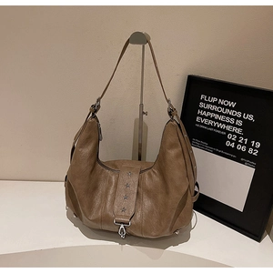 Detail of vintage brown leather hobo bag with star rivets and metallic clasp hardware