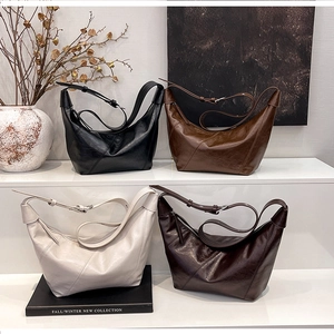 Detail view of retro leather crescent bags in black, tan, beige, and dark coffee colors