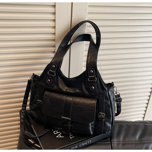 Detail of vintage black faux leather handbag showing textured surface and metal buckle