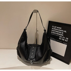 Detail of black pebbled leather hobo bag with four silver star metal studs on strap