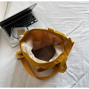Detail view of yellow nylon tote bag interior with multiple organizational pockets
