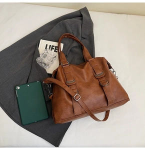 Detailed flat lay of a brown vintage tote bag with adjustable strap and metallic hardware