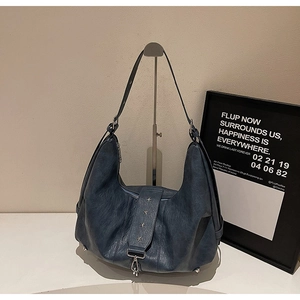 Detailed view of grey-blue leather tote featuring silver star rivets and vintage texture