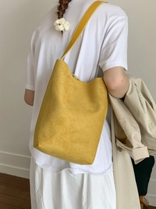 Minimalist bright yellow matte suede bucket bag with long shoulder strap for women