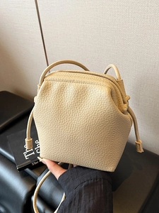 Beige lychee pattern leather crossbody bag with drawstring design and adjustable strap