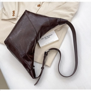 Detailed view of deep brown dumpling bag texture on a beige corduroy jacket