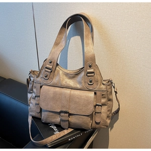 Close-up of tan leather handbag featuring front flap pocket and dual strap design