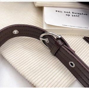 Detailed macro shot of dark brown leather strap with silver buckle and metal eyelets