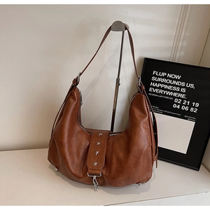 Detailed view of brown hobo bag with silver star rivets and metal spring hooks