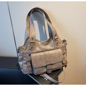 Detail of vintage faux leather tote with textured matte finish and metallic rivets