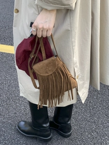Sac bandoulière marron en daim à franges bohème avec un trench-coat de printemps