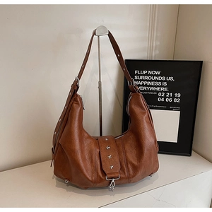 Detail of vintage brown leather hobo bag featuring silver star rivets and soft texture