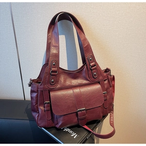 Detailed view of burgundy faux leather tote bag with functional side pockets and buckles