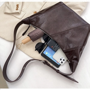 Macro detail of deep brown tote bag with geometric stitching and large capacity storage