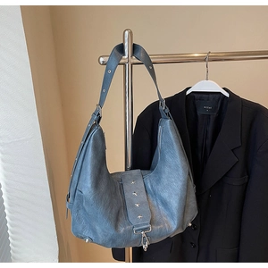 Detail view of large blue tote bag with silver star rivets and soft leather texture