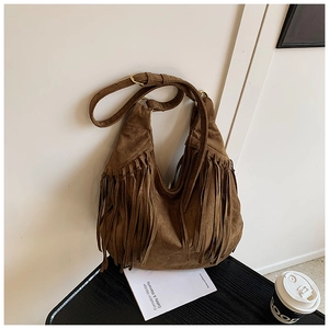 Detailed close-up of dark brown suede crescent bag featuring long decorative tassels