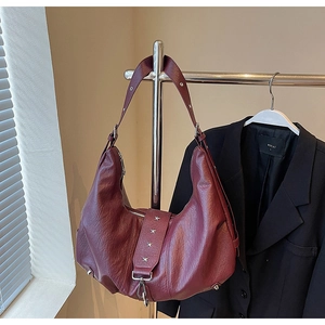 Detail of burgundy PU leather tote bag featuring silver star rivets and grained texture