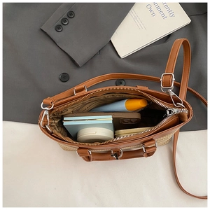 Detail view of woven straw tote bag interior showing capacity for cosmetics and phone