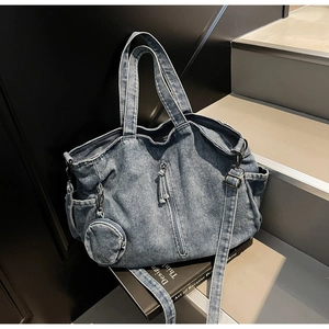Detail of blue washed denim tote bag with round coin purse and adjustable strap