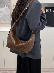 Retro brown oil wax leather half-moon shoulder bag styled with a minimalist outfit