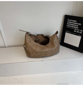 Detail view of the vintage brown faux leather croissant bag with silver zipper and lining