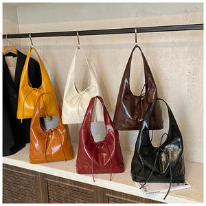 Detail view of bow-knot accents on retro pleated hobo buckets in diverse colors