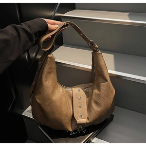 Detail view of brown vintage leather tote with silver star rivets and hobo half-moon shape